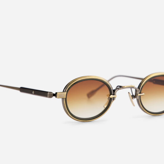 With a small, round design, the Algedi-T AG/AS-1 sunglasses combine antique gold and antique silver frames with an olive