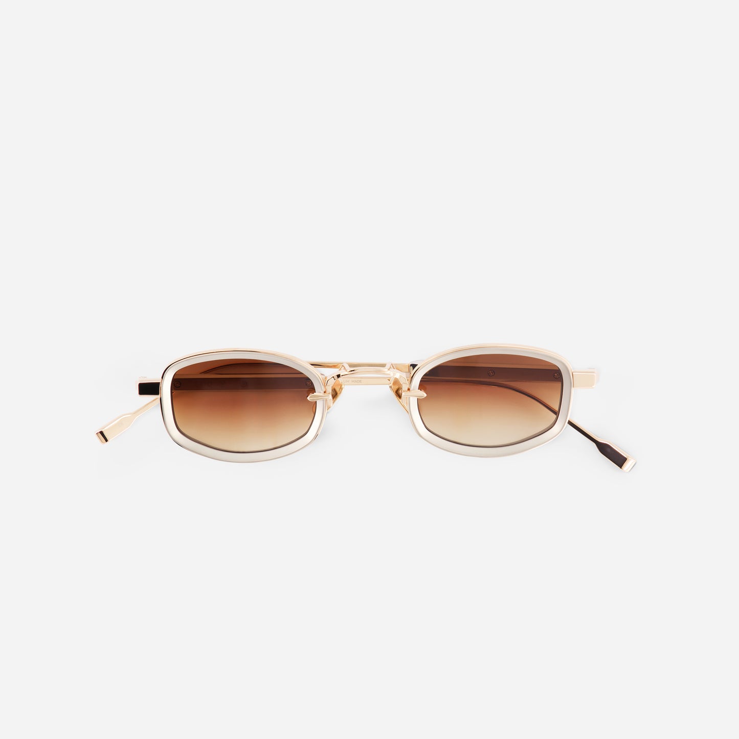 Sunglasses with gold frame and brown lenses on a white background