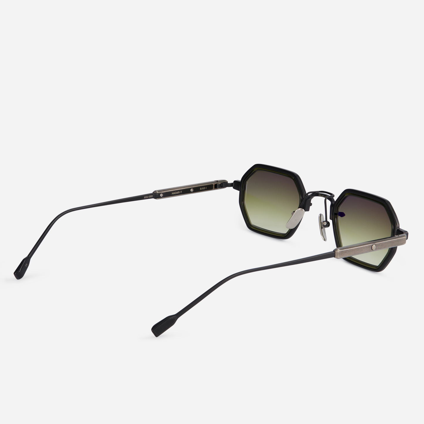 The Hadar-T B/AS-1 eyeglasses showcase a titanium frame with black mat and antique silver coatings, a green olive takiron rim insert, and gradient green lenses.