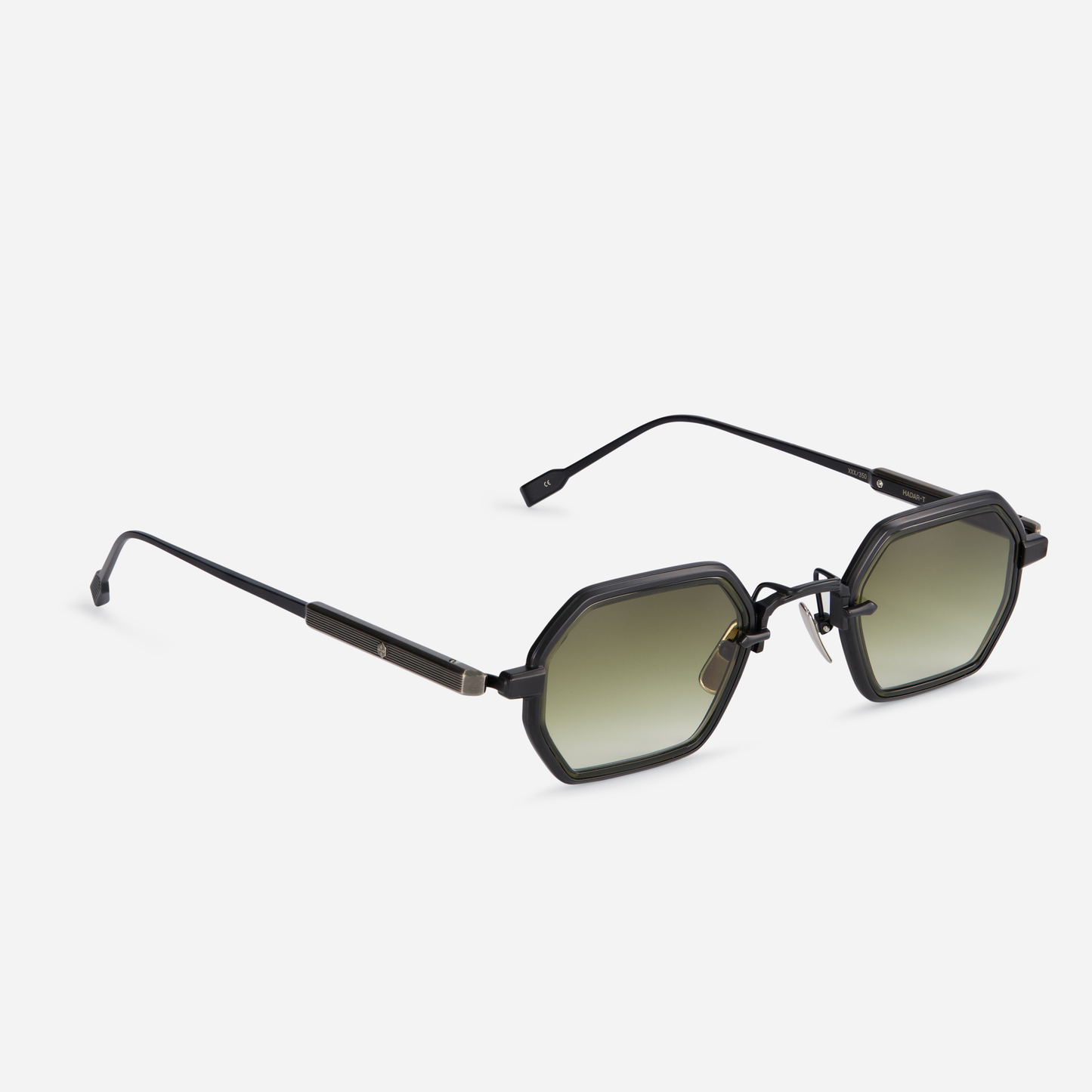 Hadar-T B/AS-1 is designed with a titanium frame, black mat and antique silver coating, green olive takiron rim insert, and gradient green lenses.