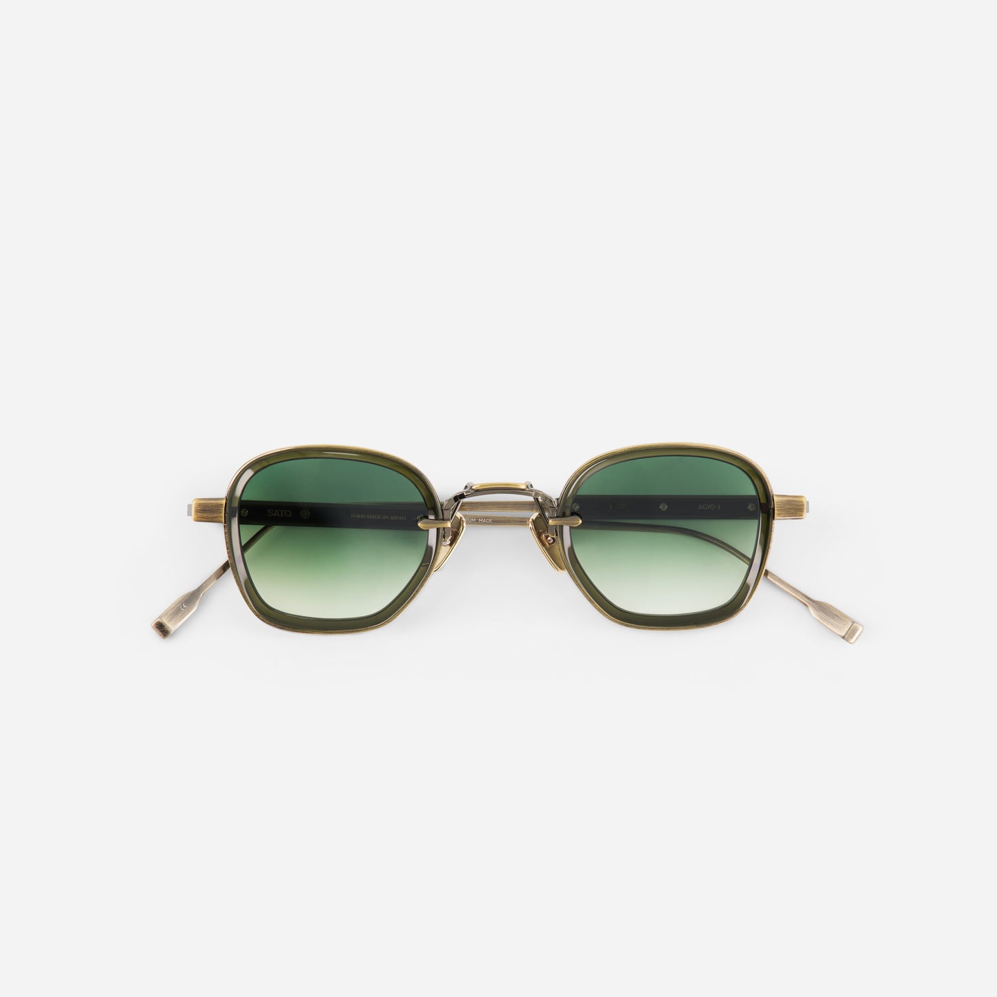 Antique gold sunglasses with green gradient lenses and gold frame on a white background