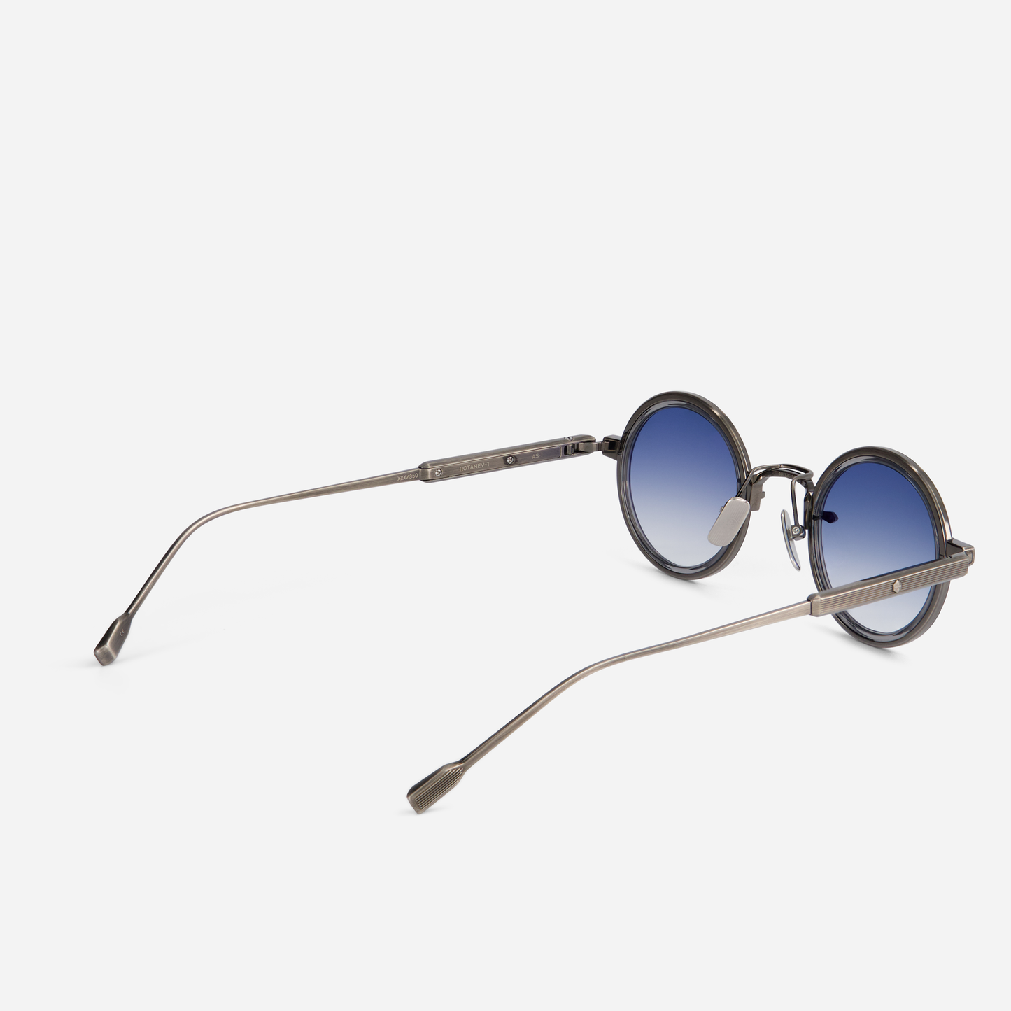 Rotanev-T AS-1 comes with a titanium frame, antique silver coating, crystal grey takiron rim insert, and gradient blue lenses.