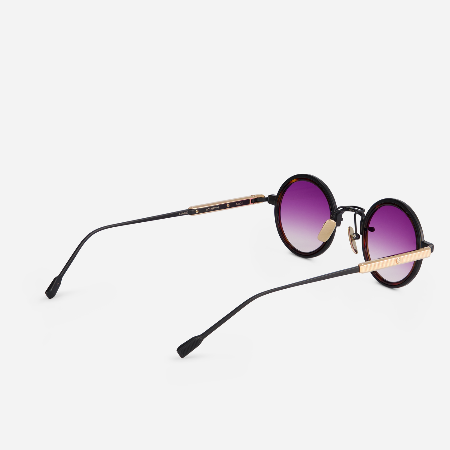 Rotanev-T B/RG is designed with a titanium frame, black mat and rose gold coating, tortoise takiron rim insert, and gradient purple lenses.