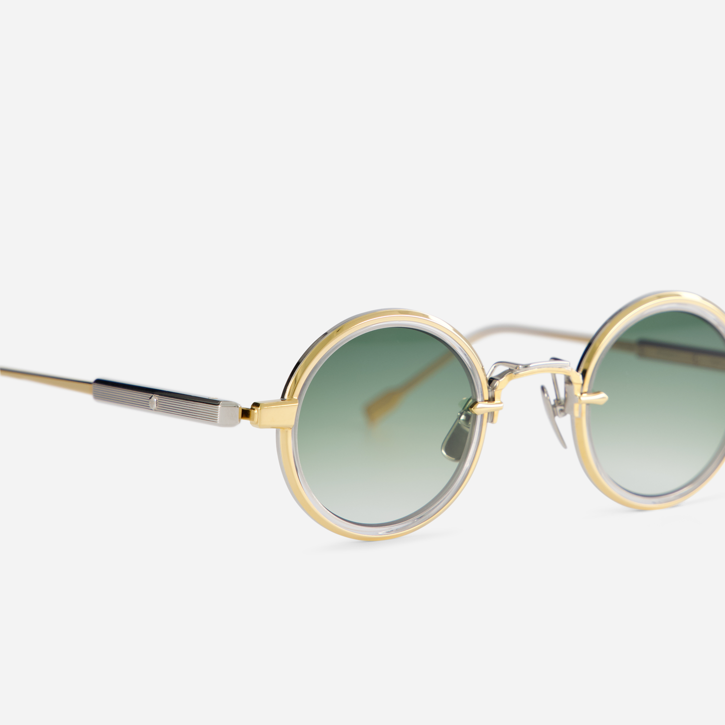 Rotanev-T YG/P-1 is designed with a titanium frame, yellow gold, and platinum coating, crystal takiron rim insert, and gradient green lenses.