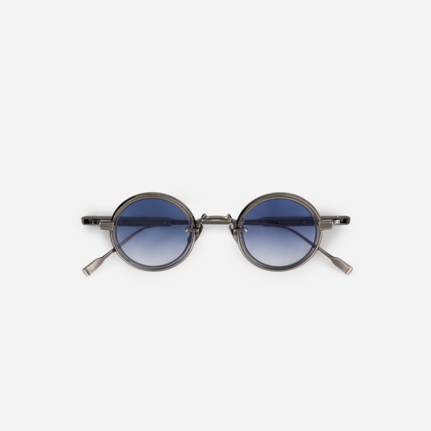 The Rotanev-T AS-1 features a titanium frame with an antique silver coating, a crystal grey takiron rim insert, and gradient blue lenses.