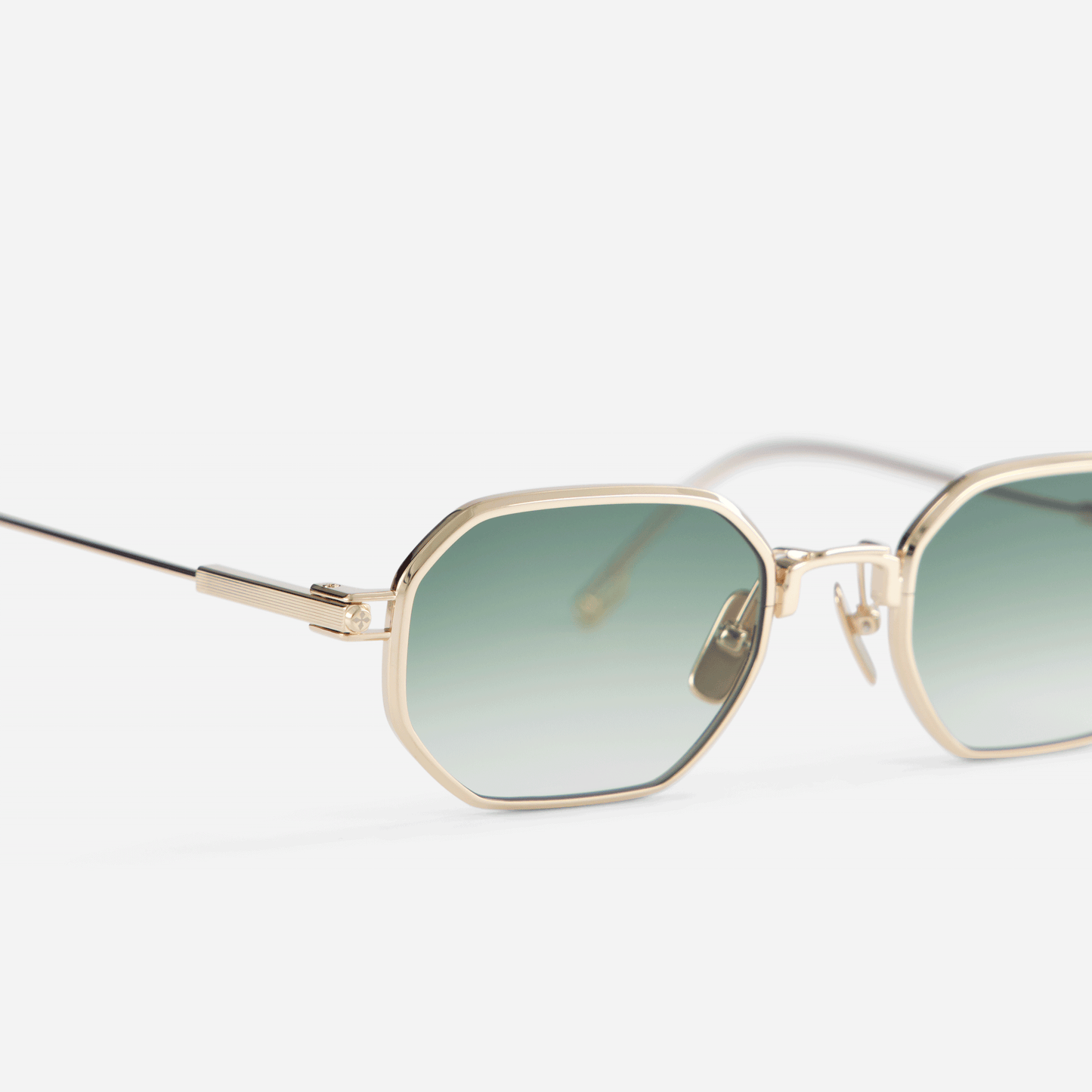 Timir S502 hexagonal glasses, crafted from pure Japanese titanium in the enchanting Lunar Gold shade, accentuated by alluring olive gradient lenses.