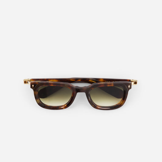 Tortoiseshell sunglasses with gold accents on a white background
