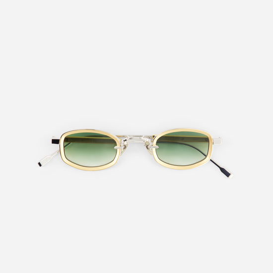 Sunglasses with gold frame and green gradient lenses on a white background