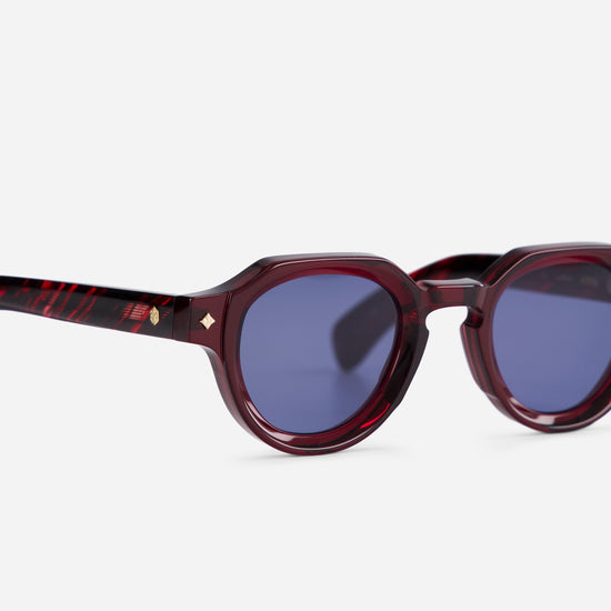 In a close-up side view, the Atria VE-1 accentuates the vibrant BL16 blue lenses, complemented by the dark red and red tortoise frames.