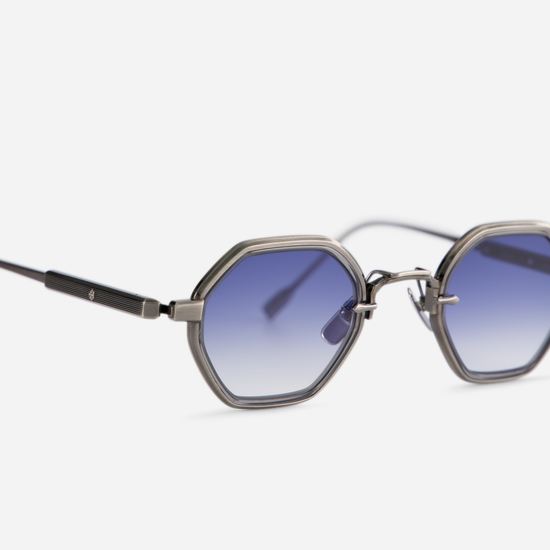 his eyewear, Arraï-T AS-1 by SATO, includes a titanium frame with an antique silver coating, a crystal grey takiron rim insert, and gradient blue lenses.
