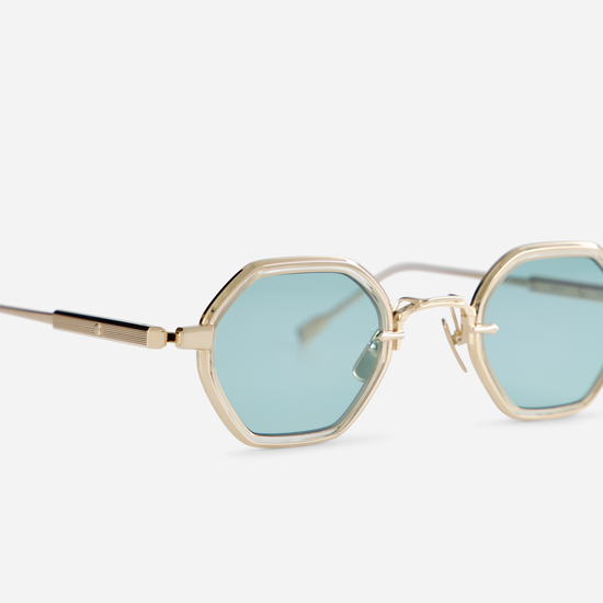 Arraï-T LG is designed with a titanium frame, lunar gold coating, honey yellow takiron rim insert, and turquoise lenses.