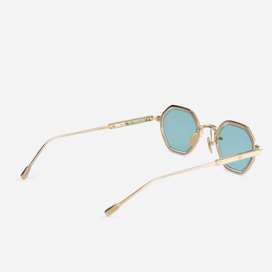 This eyewear, Arraï-T LG-1, includes a titanium frame with lunar gold coating, honey yellow takiron rim insert, and turquoise lenses.