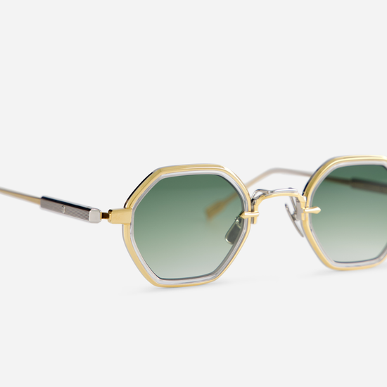 Arraï-T YG/P-1 by Sato is designed with a titanium frame, yellow gold, and platinum coating, crystal takiron rim insert, and gradient green lens.