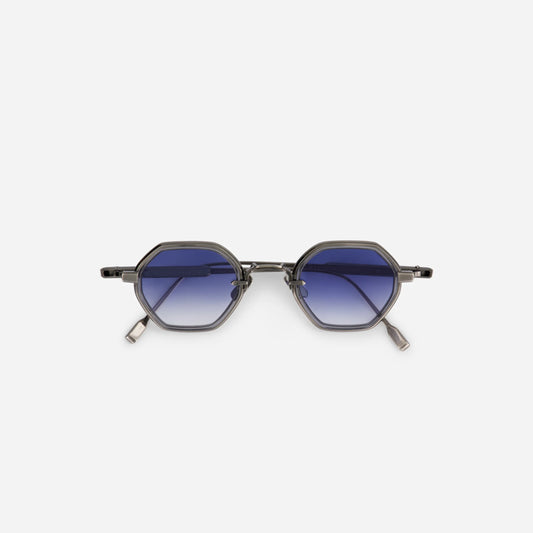 Arraï-T AS-1 has a titanium frame with an antique silver coating, a crystal grey takiron rim insert, and gradient blue lenses.