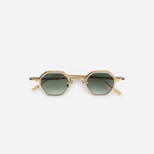 The Sato Arraï-T YG/P-1 features a titanium frame with a yellow gold and platinum coating, crystal takiron rim insert, and gradient green lens.