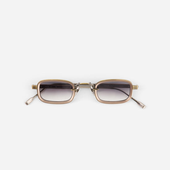 Sunglasses with gold frame and dark lenses on a white background
