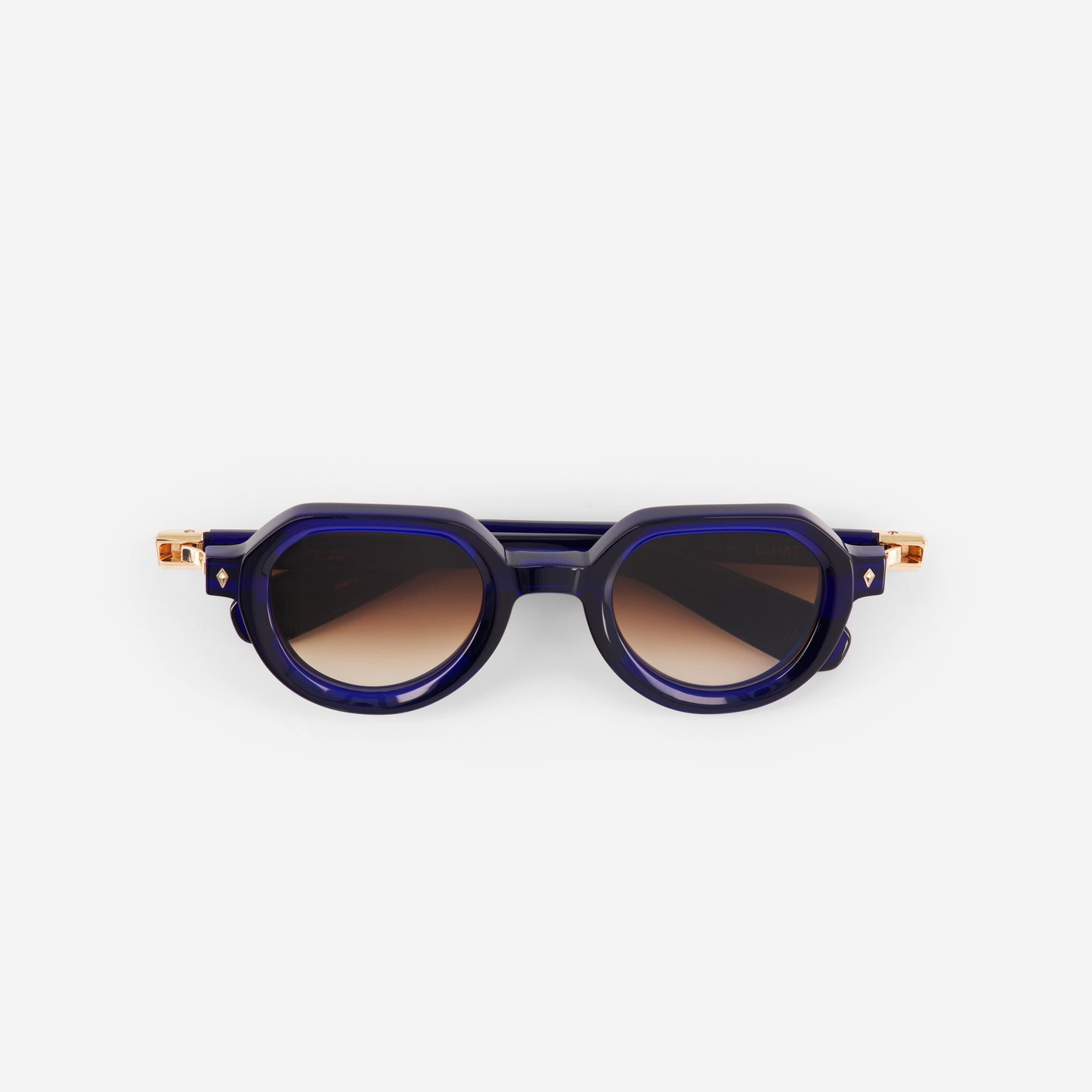 Blue sunglasses with gold accents and gradient brown lenses on a white background