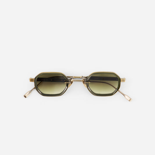 Sunglasses with gold frame and gradient lenses on a white background