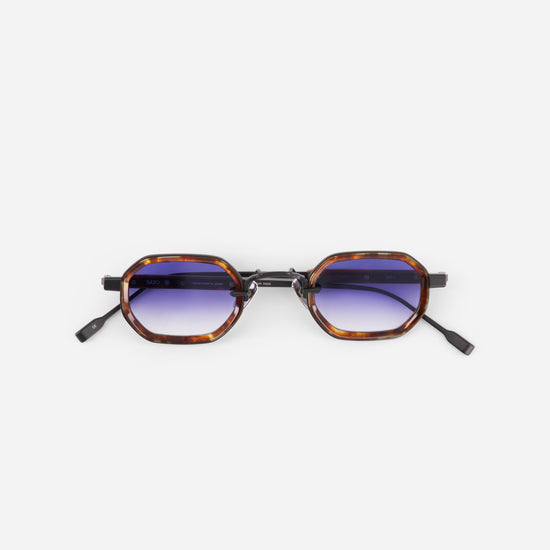 Sunglasses with tortoiseshell frame and gradient blue lenses on a white background