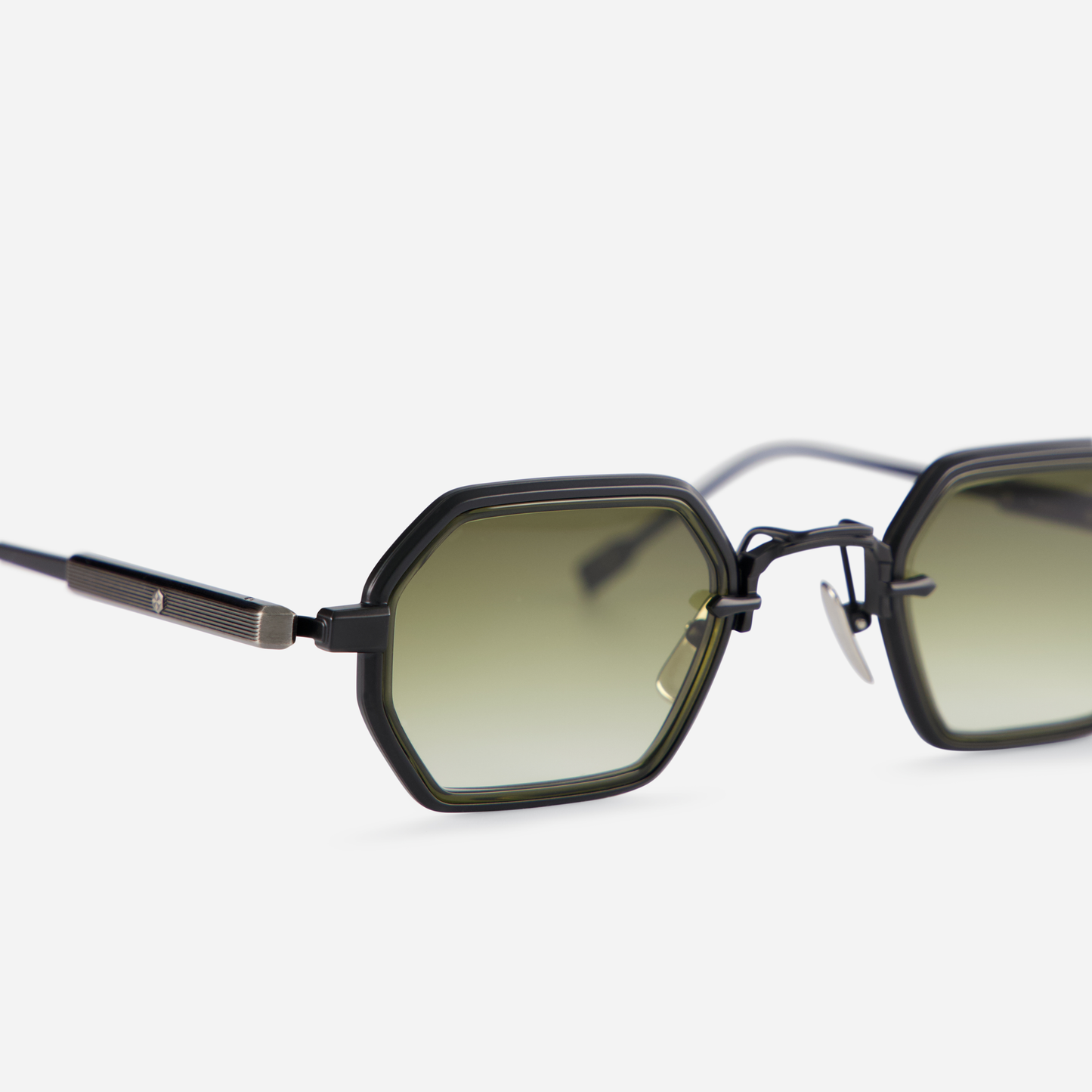 This eyewear, Hadar-T B/AS-1, includes a titanium frame with black mat and antique silver coatings, a green olive takiron rim insert, and gradient green lenses.