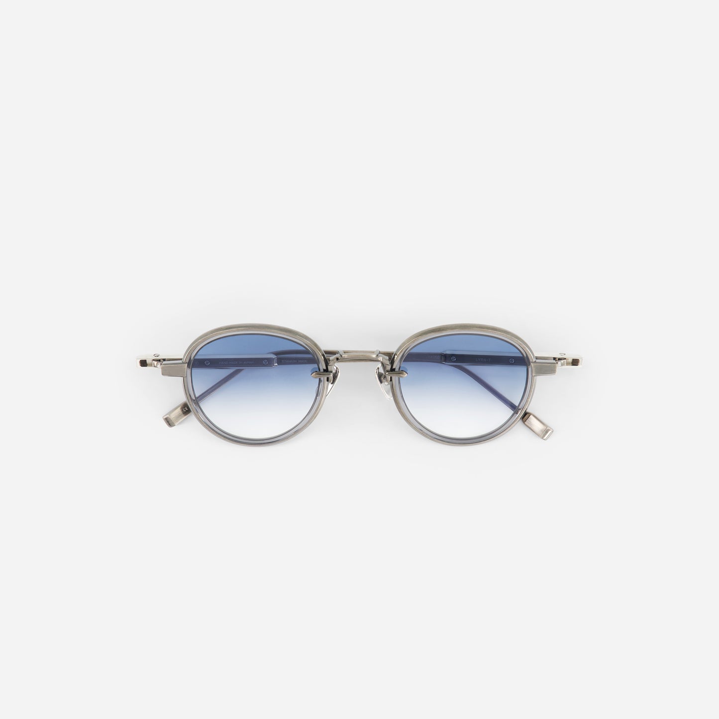 Round titanium sunglasses with gradient blue lenses on a white background