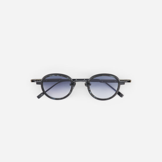 Round matte black sunglasses with a black frame and gradient lenses on a white background