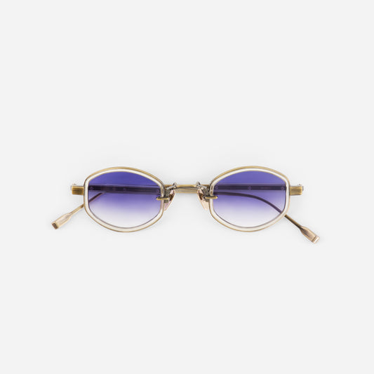 Sunglasses with gold frame and blue gradient lenses on a white background