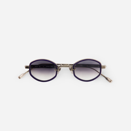 Sunglasses with purple lenses and gold frame on a white background