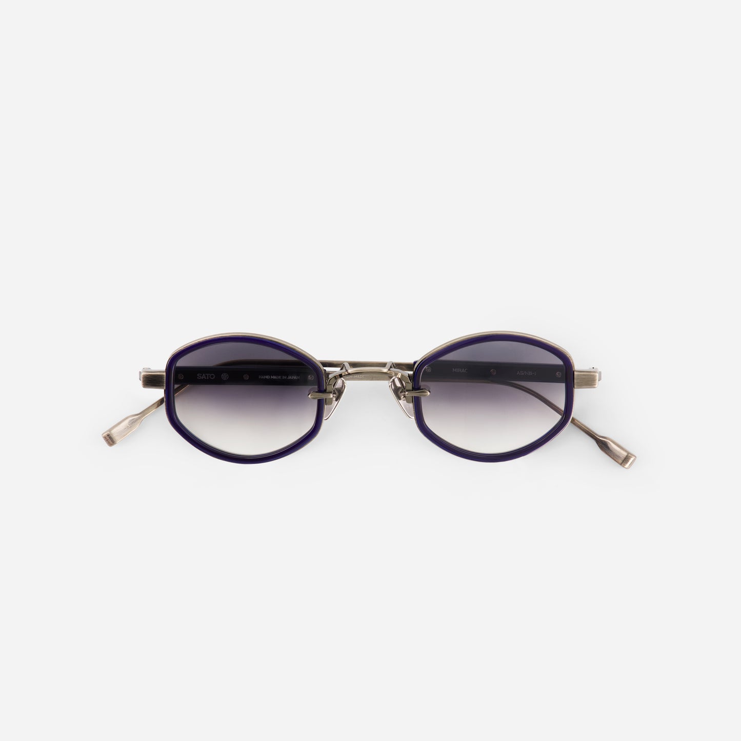 Sunglasses with purple lenses and gold frame on a white background