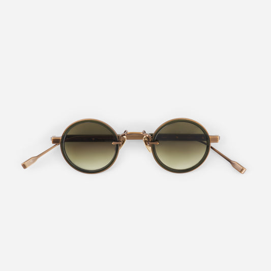 Round sunglasses with gold frame and gradient lenses on a white background