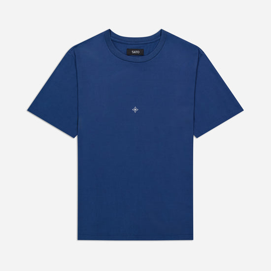 Blue t-shirt with a small logo on a light gray background