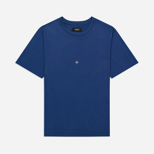 Blue t-shirt with a small logo on a light gray background