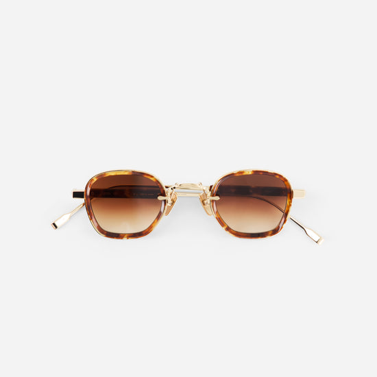 Sunglasses with tortoiseshell frame and brown gradient lenses on a white background