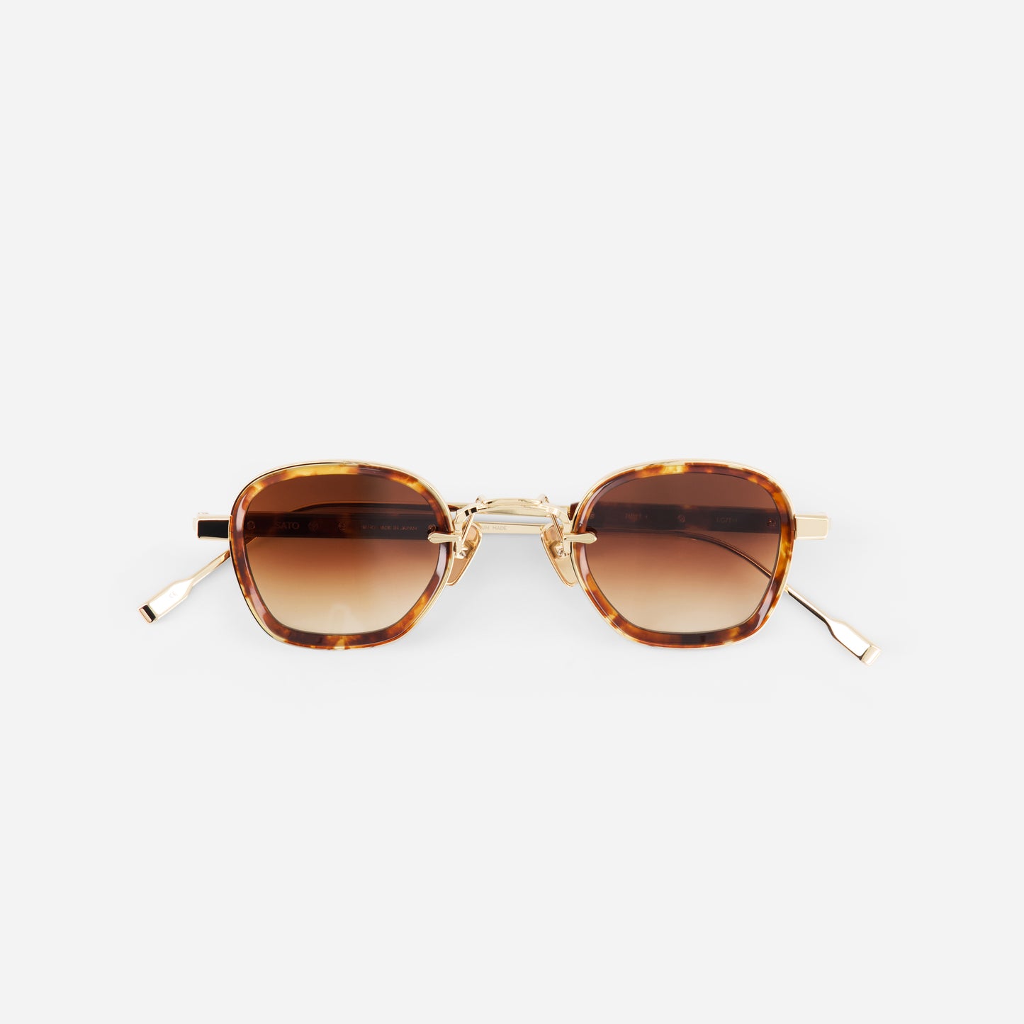 Sunglasses with tortoiseshell frame and brown gradient lenses on a white background