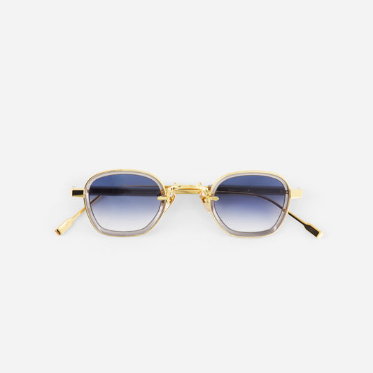 Gold-framed sunglasses with blue gradient lenses on a white background