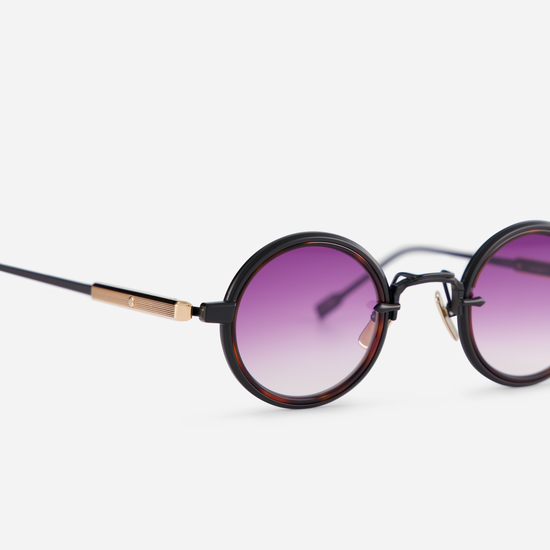 This eyewear, Rotanev-T B/RG, includes a titanium frame with black mat and rose gold coating, a tortoise takiron rim insert, and gradient purple lenses.