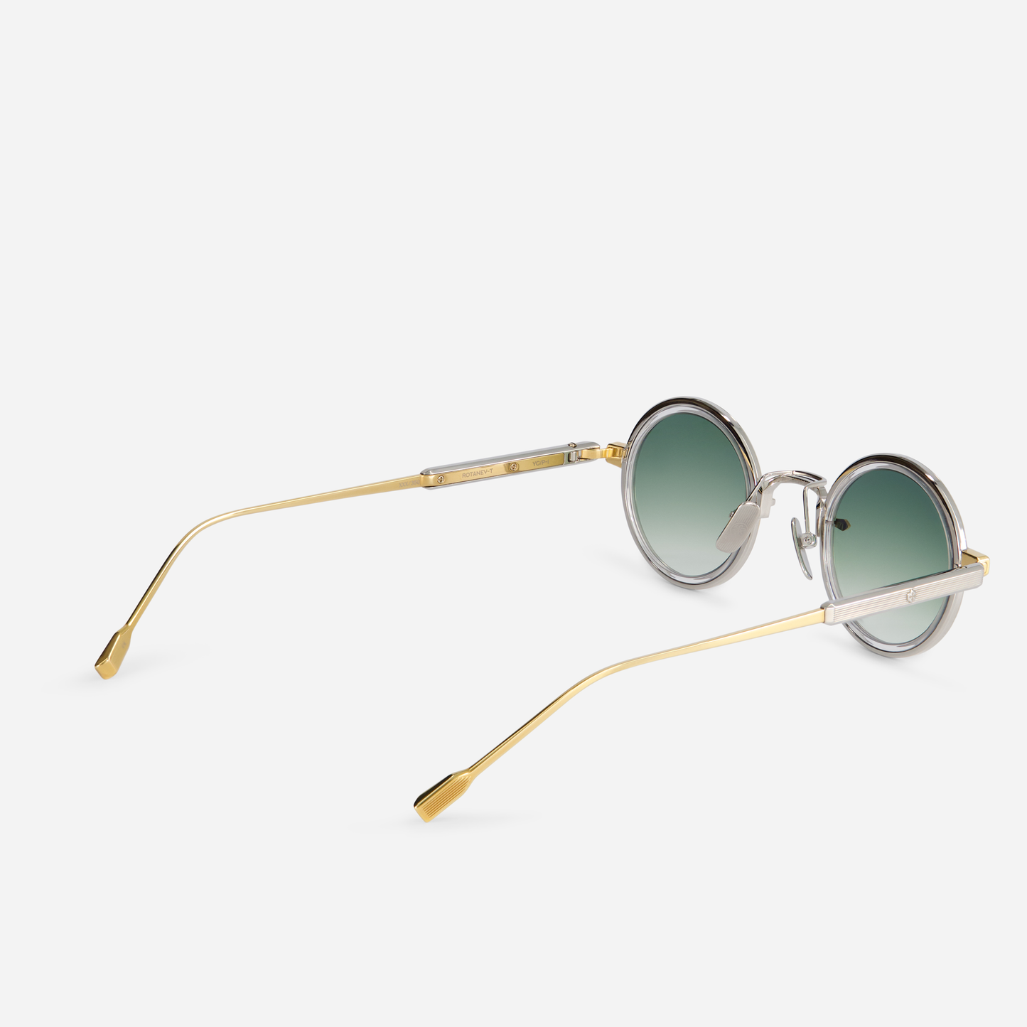 This eyewear, Rotanev-T YG/P-1, includes a titanium frame with yellow gold and platinum coatings, a crystal takiron rim insert, and gradient green lenses.