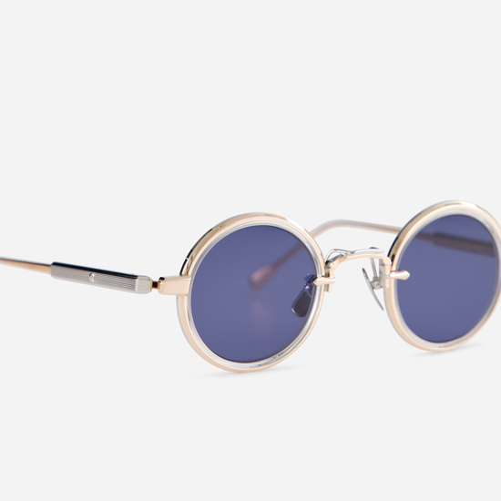 This eyewear, Rotanev-T RG/P-1, includes a titanium frame with rose gold and platinum coatings, a crystal takiron rim insert, and BL-16 blue lenses. Sato Eyewear