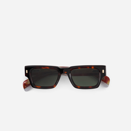 Sunglasses with tortoiseshell frame and dark lenses on a white background