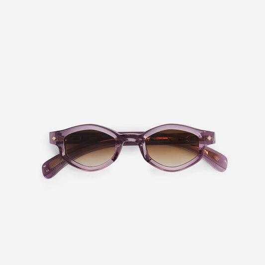 Sirius PC-1 sunglasses feature a striking purple crystal frame with elegant gold details, complemented by rich brown gradient lenses.