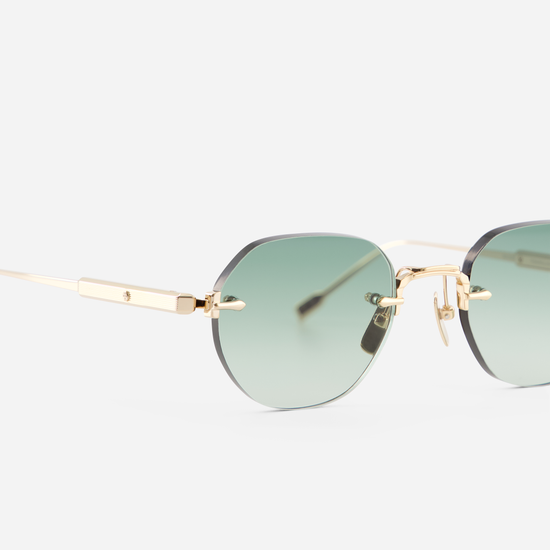 Unveil a touch of luxury with Terebellum Rimless, showcasing Lunar Gold accents and green-tinted lenses.