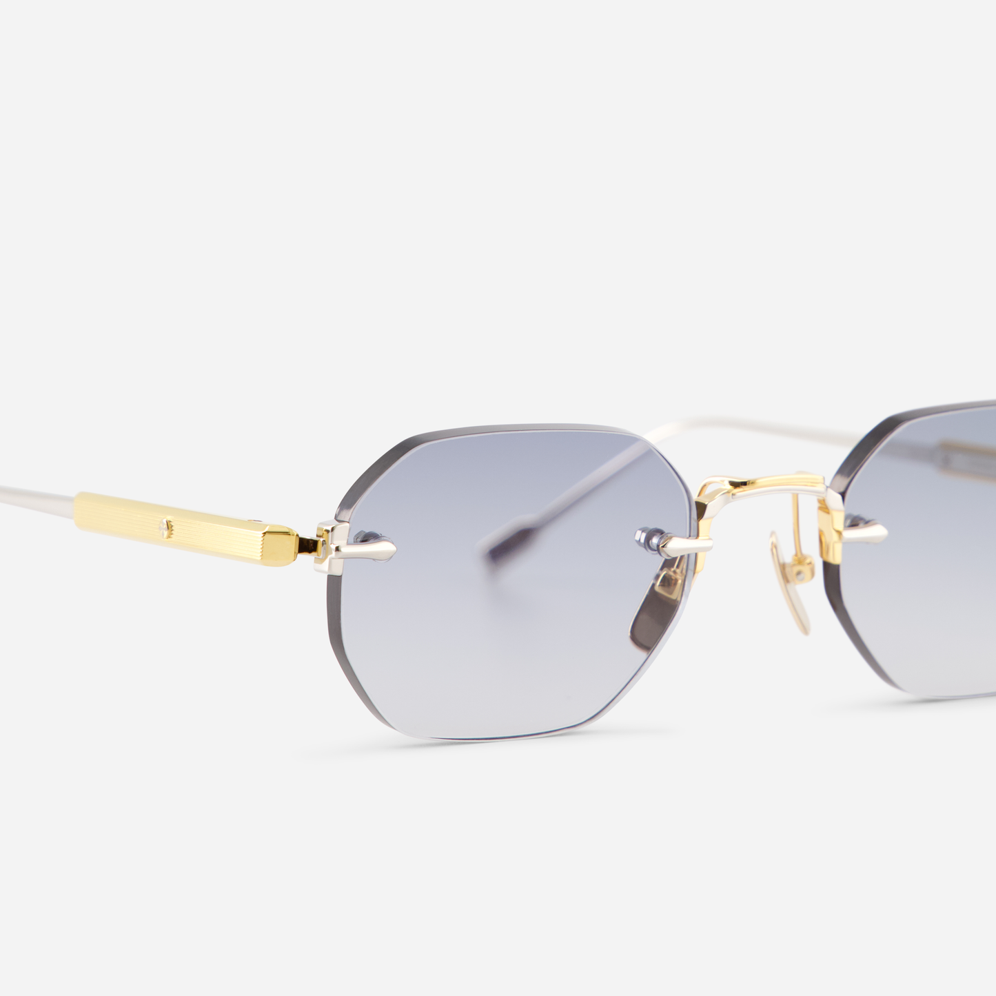 Terebellum II S703, showcasing yellow gold and platinum accents and a rounded hexagonal rimless design, perfectly complemented by captivating blue lenses.