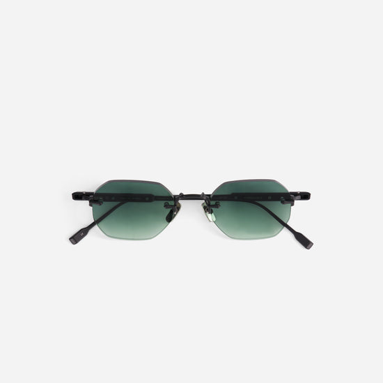 Sunglasses with green gradient lenses and black temples on a white background