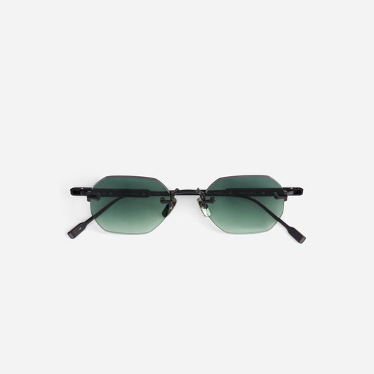 Sunglasses with green gradient lenses and black temples on a white background