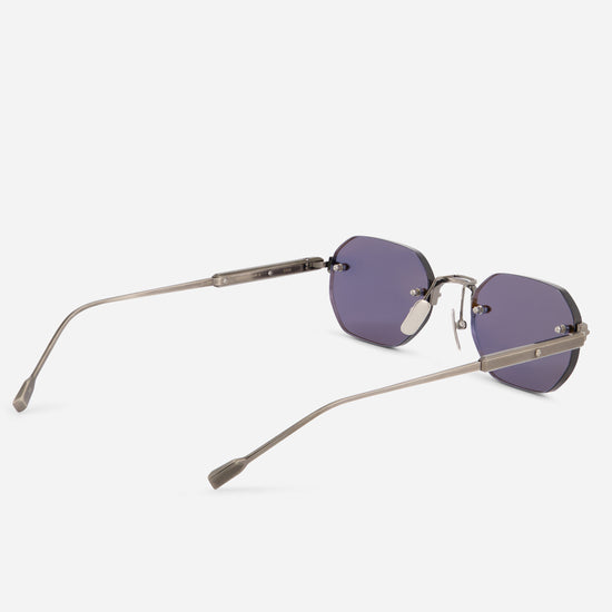 A pair of rimless sunglasses with muted purple lenses and a thin, titanium silver frame, shown from a three-quarters angle on a light gray background.