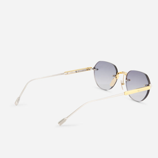 Oversized square sunglasses with gradient gray lenses, gold metal frames, and slim silver temples, shown from a side angle on a light gray background.