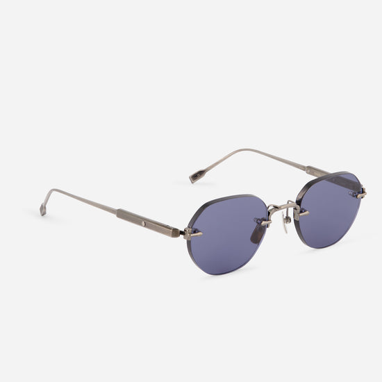  round sunglasses with a silver-tone metal frame and dark blue-gray tinted lenses, shown on a light gray background.