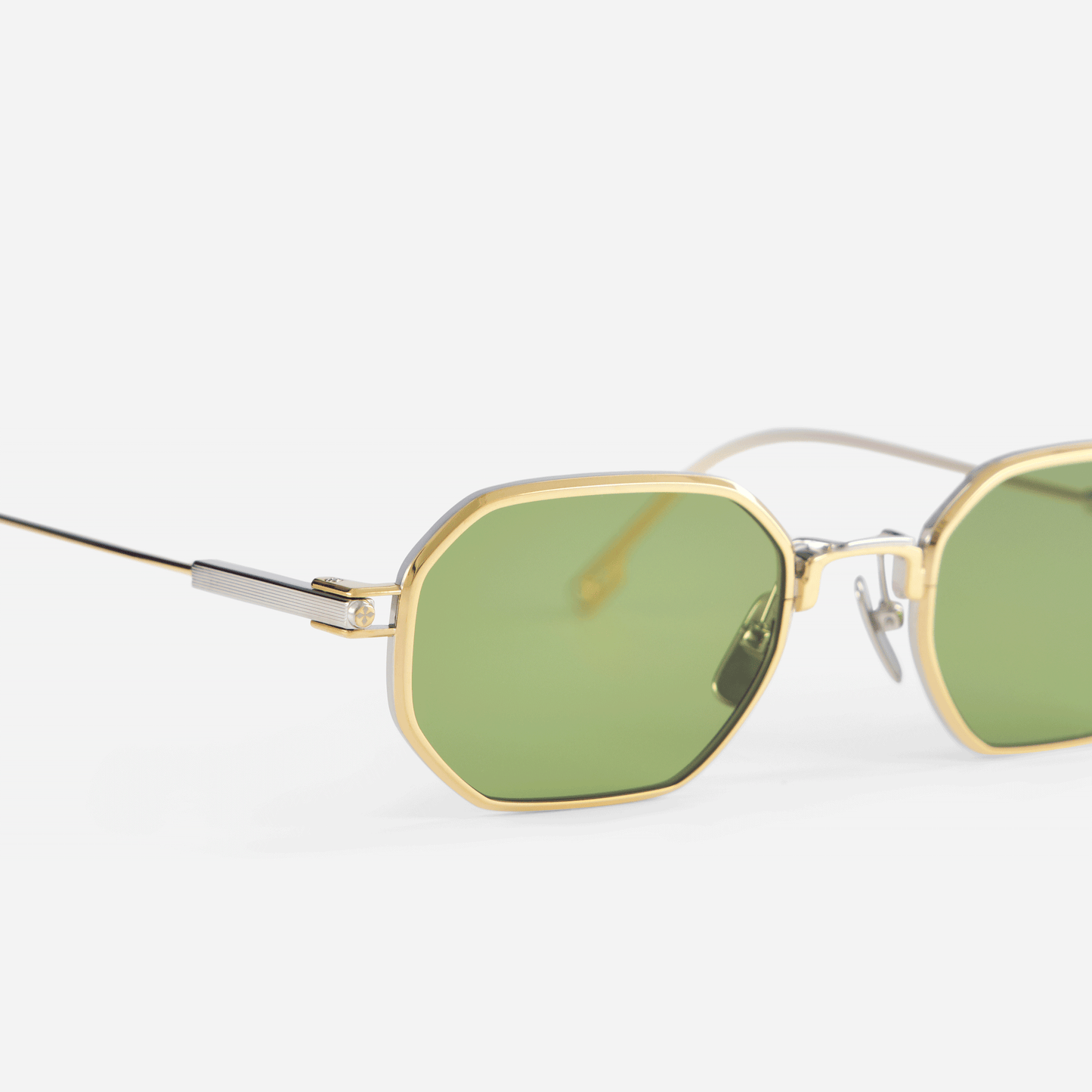 Timir S502 hexagonal glasses, meticulously constructed from pure Japanese titanium in the captivating Yellow Gold and Platinum hues, enhanced by striking green lenses.
