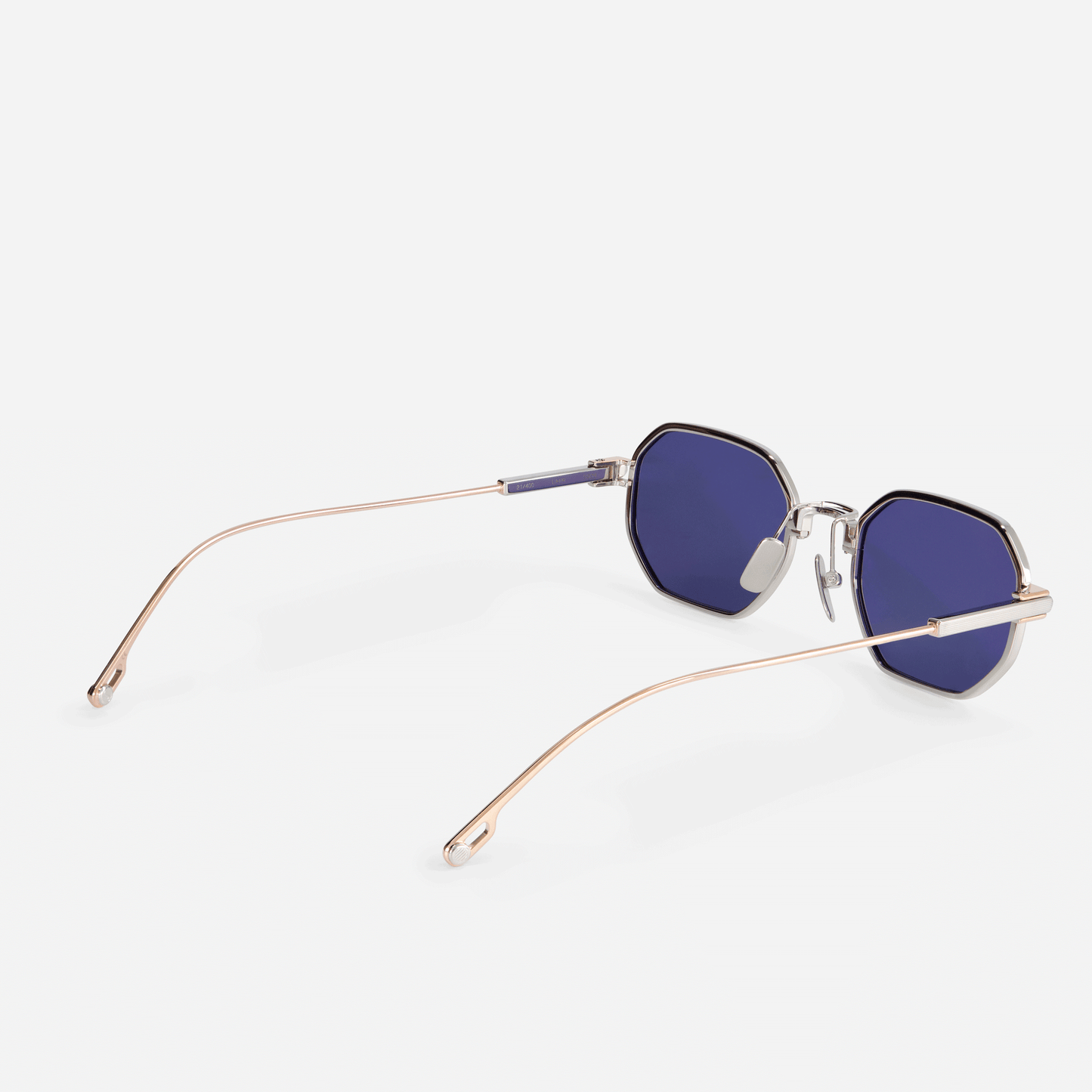  Timir S504 hexagonal glasses, a highlight from the latest Sato SS23 collection. Crafted from premium Japanese titanium in Rose Gold and Platinum, these glasses boast stylish blue-tinted lenses, perfect for men and women with a taste for sophistication.