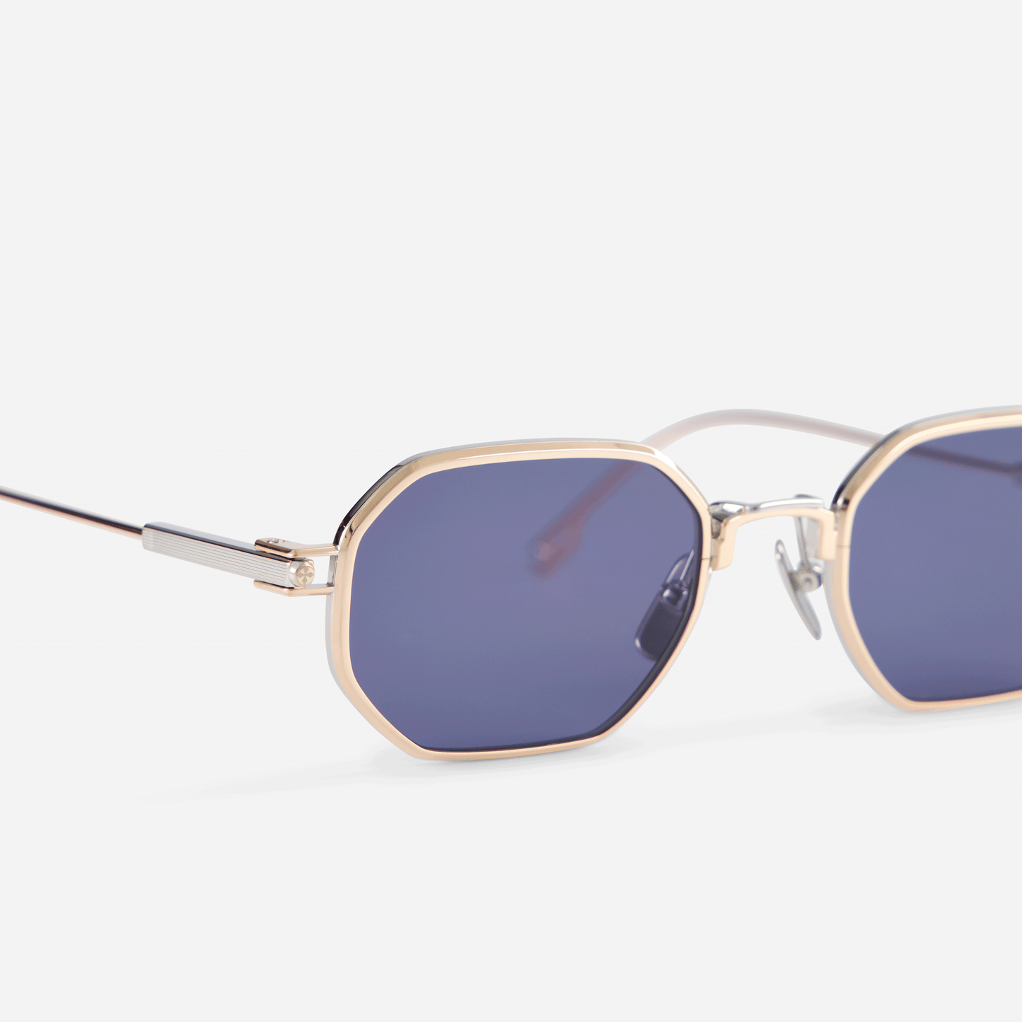 Timir S504 hexagonal glasses, part of the exclusive Sato SS23 collection. Made from pure Japanese titanium in Rose Gold and Platinum, these glasses showcase blue-tinted lenses that effortlessly complement the style of both men and women.